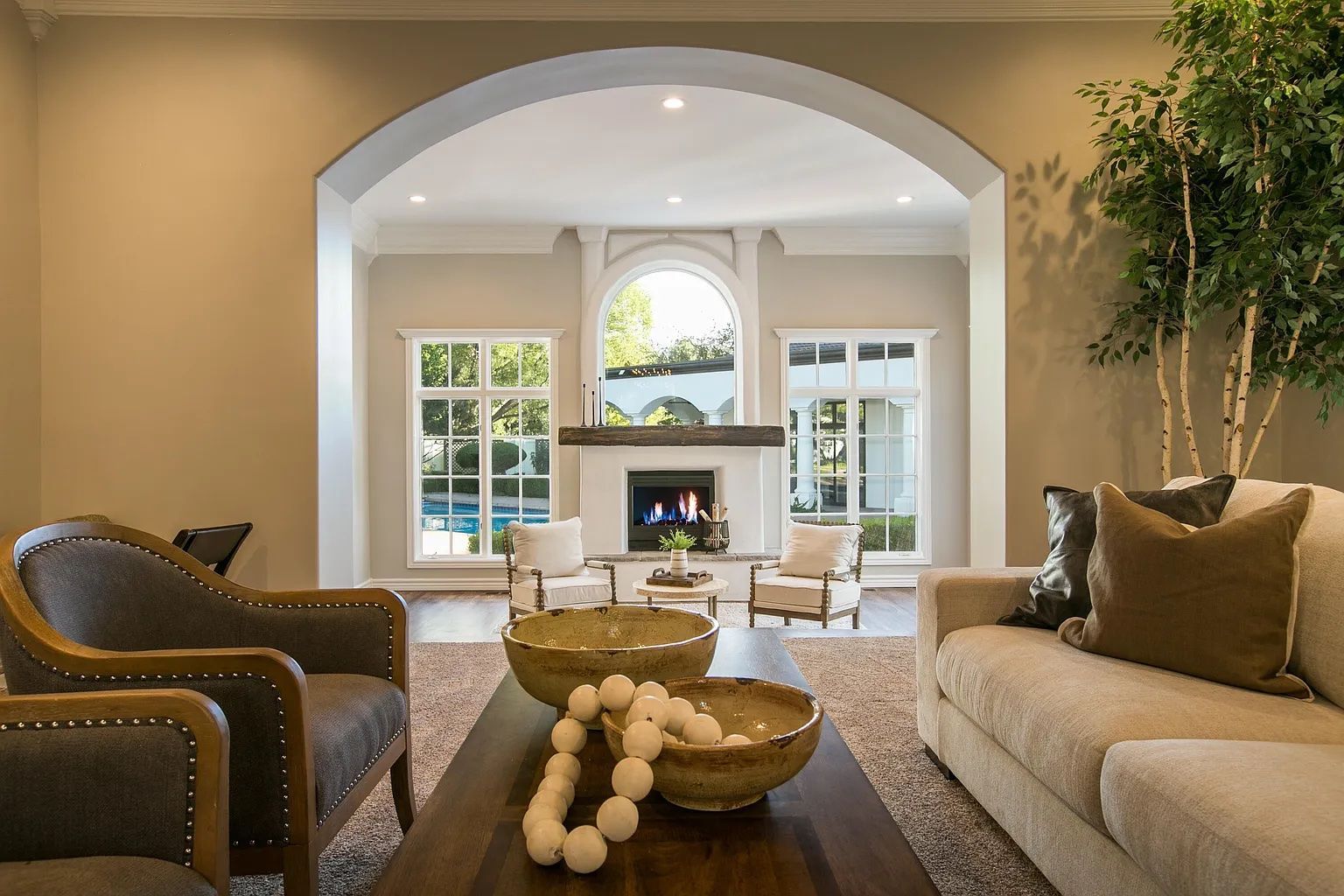 A living room with a couch , chairs , coffee table and fireplace.
