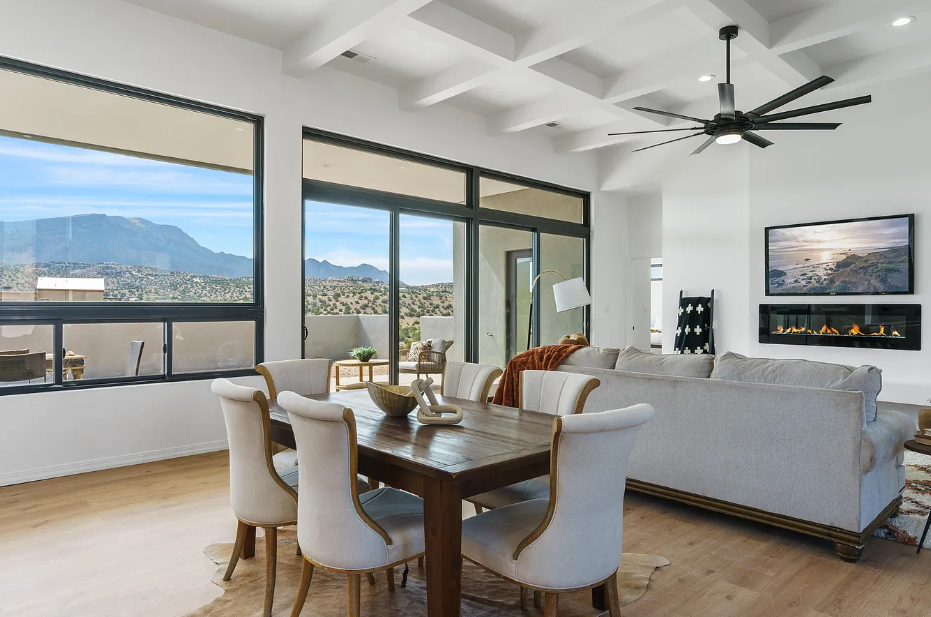 A living room with a dining table and chairs and a ceiling fan.