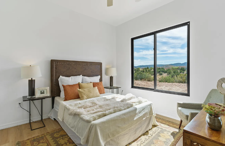 A bedroom with a large bed and a large window.