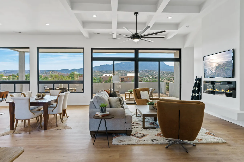 A living room with a couch , chairs , table and television.