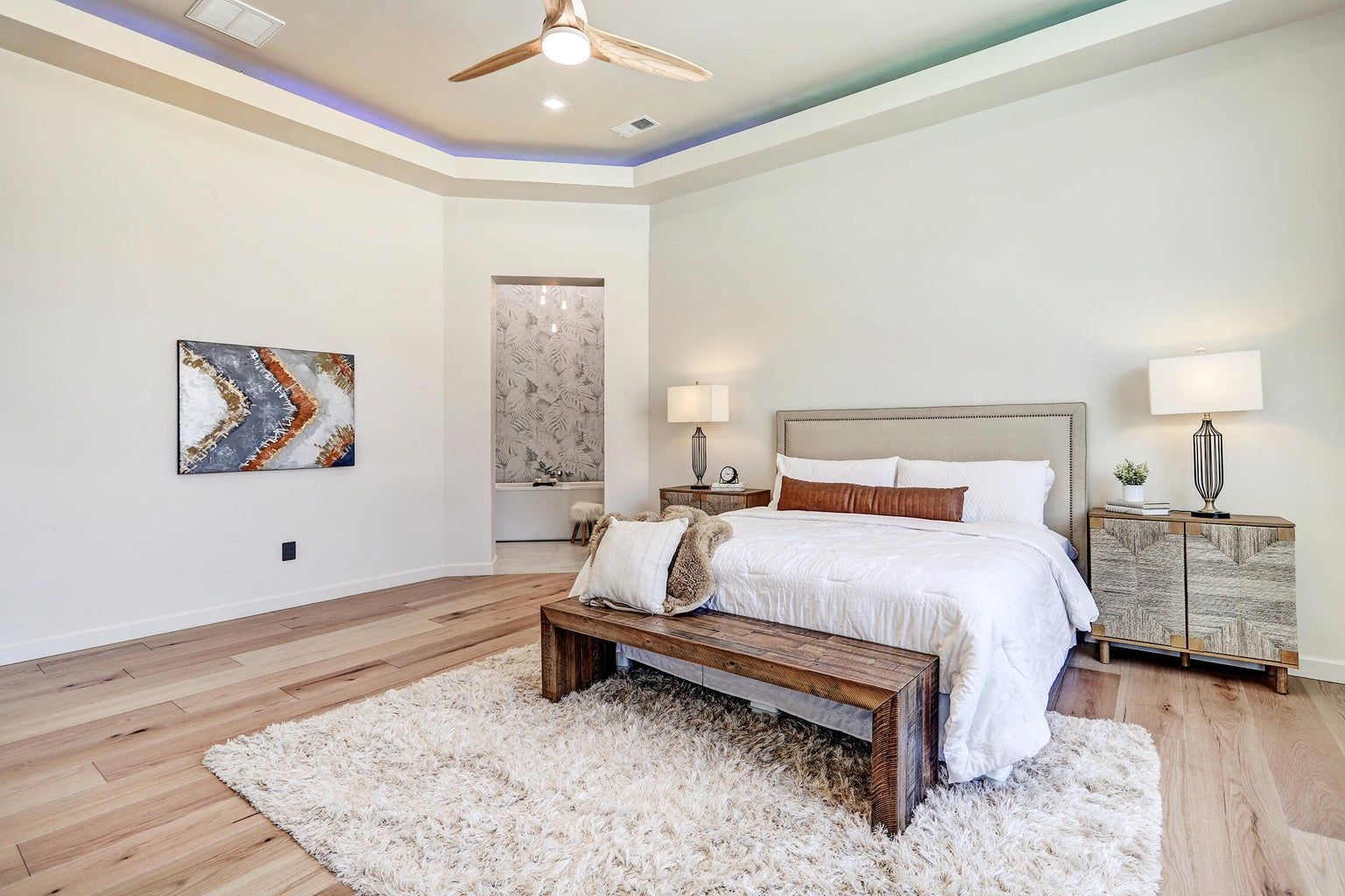 A bedroom with a bed , nightstand , rug and ceiling fan.