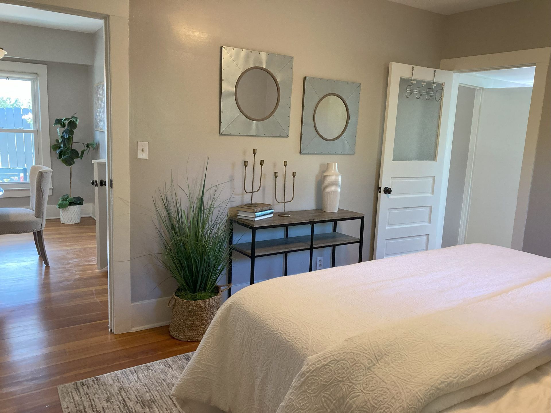 A bedroom with a bed , dresser , table and chairs.