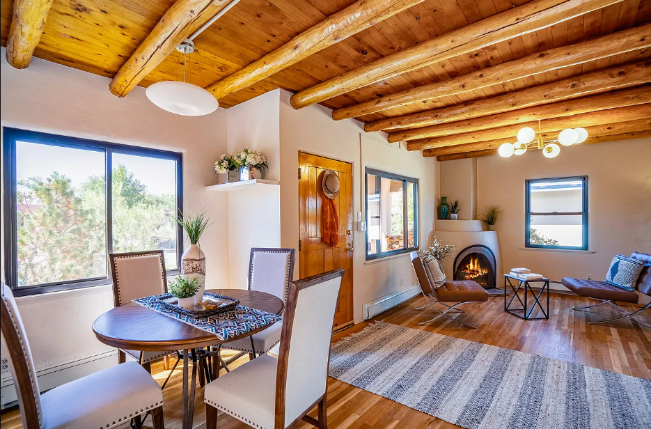 A living room with a table and chairs and a fireplace.