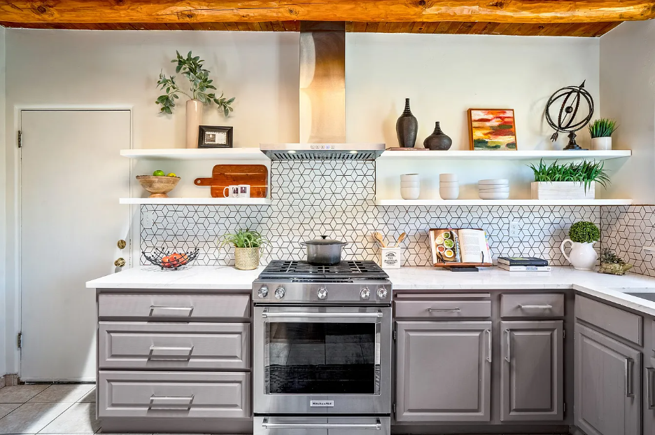 A kitchen with stainless steel appliances and gray cabinets.