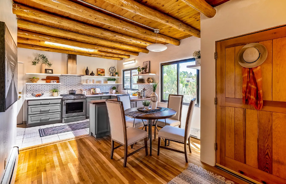 A kitchen and dining room in a house with wooden beams.