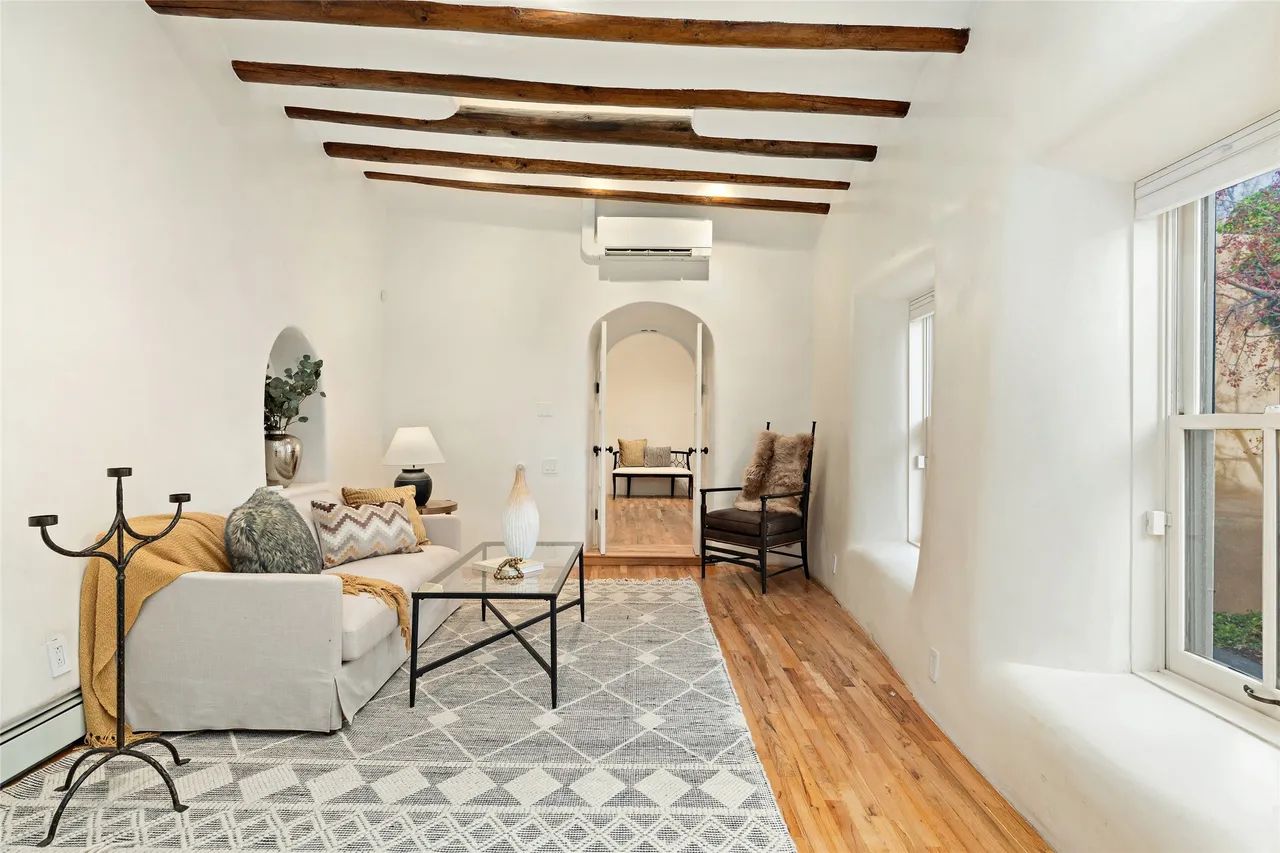 A living room with a couch , coffee table , and chairs.