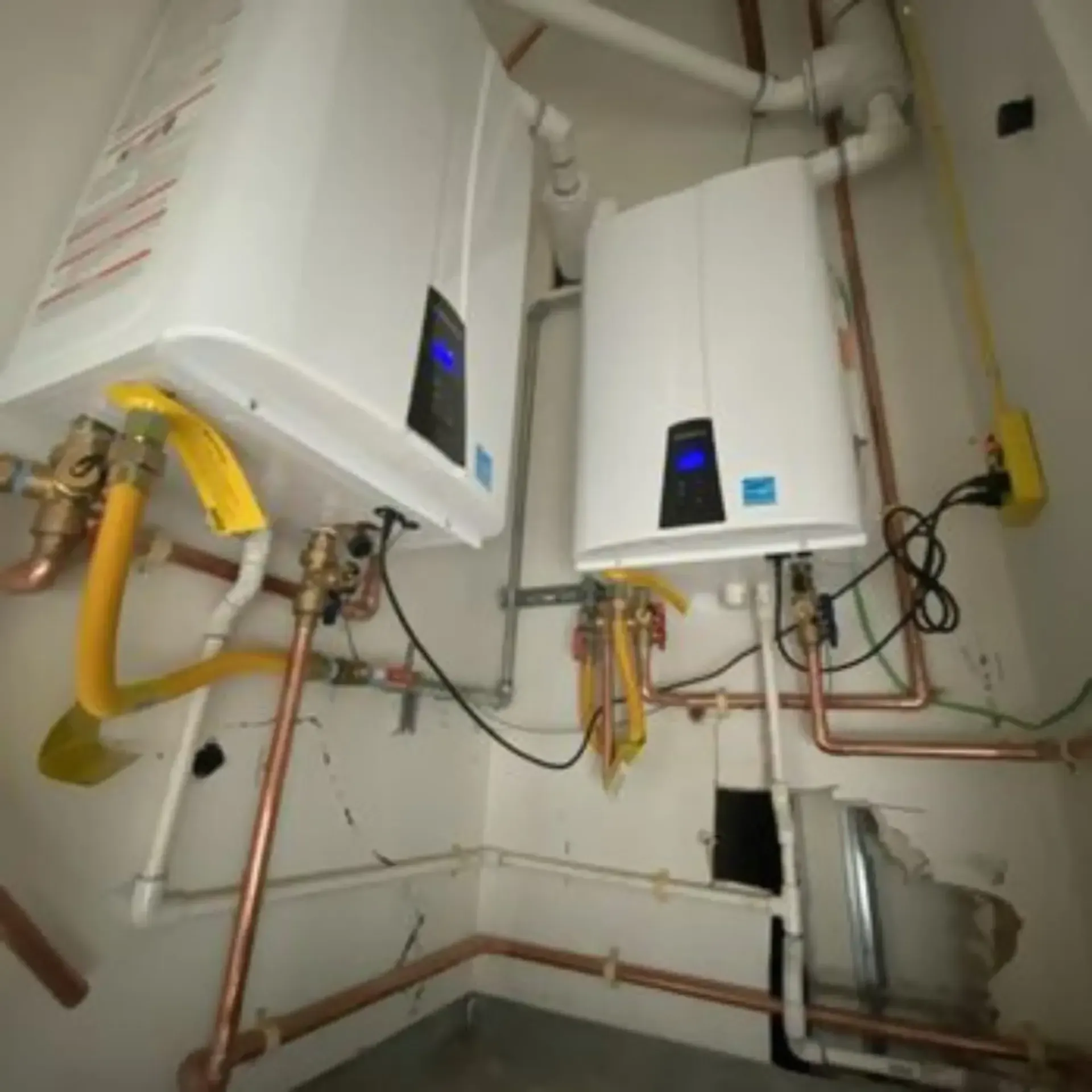 Pipex Plumbing - Two water heaters in a room with copper pipes