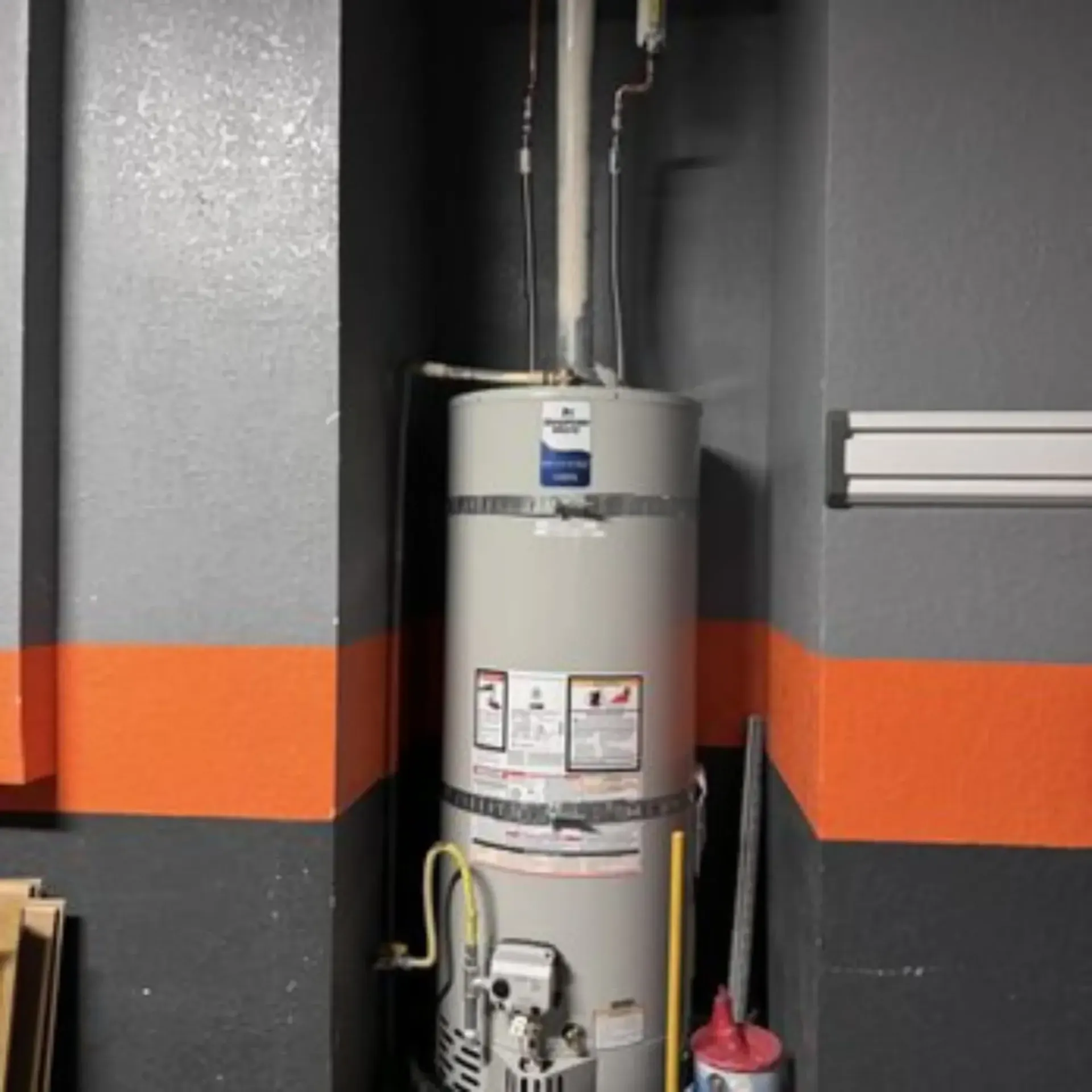 Pipex Plumbing - A water heater is sitting in a room next to a mop