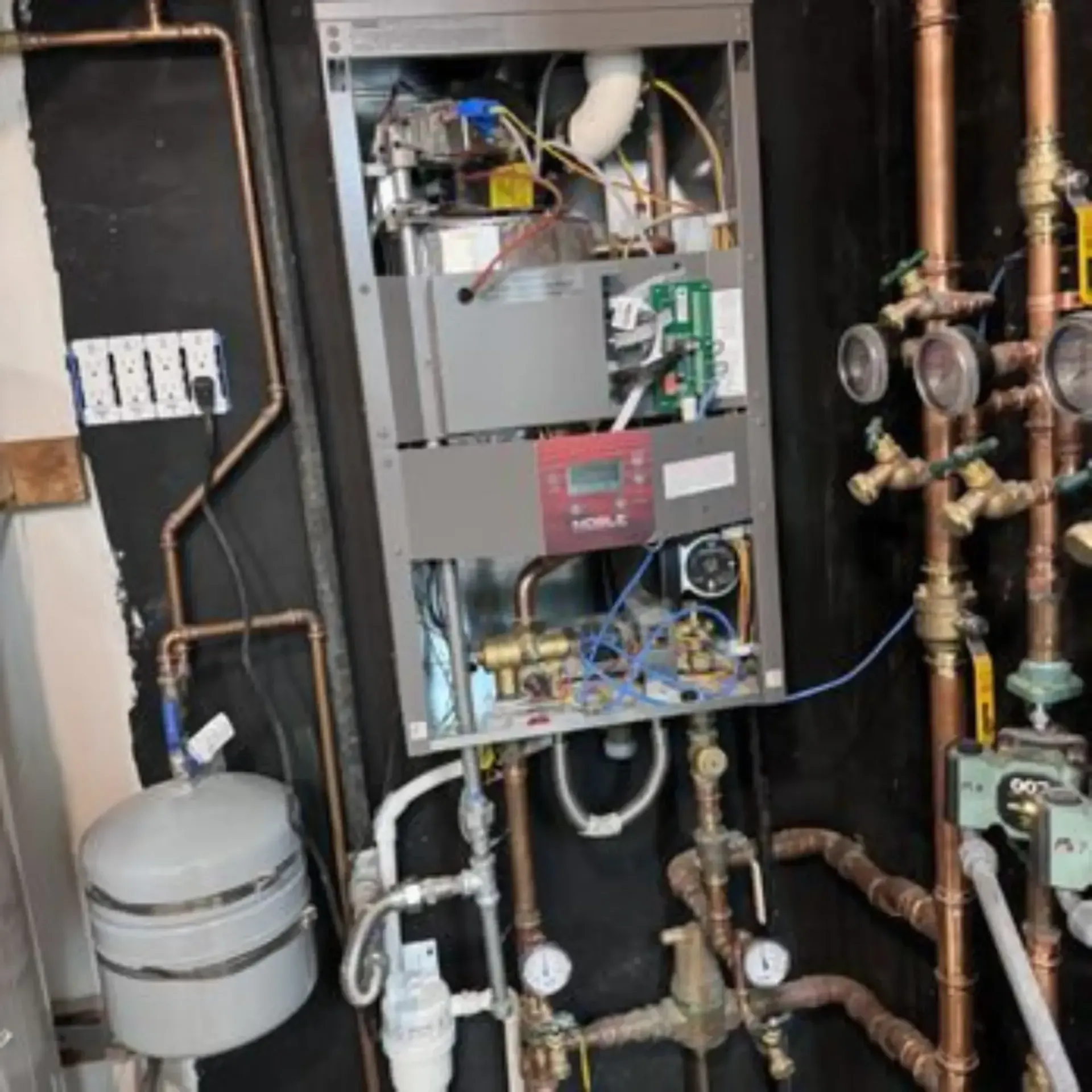 Pipex Plumbing - The inside of a boiler with copper pipes connected to it