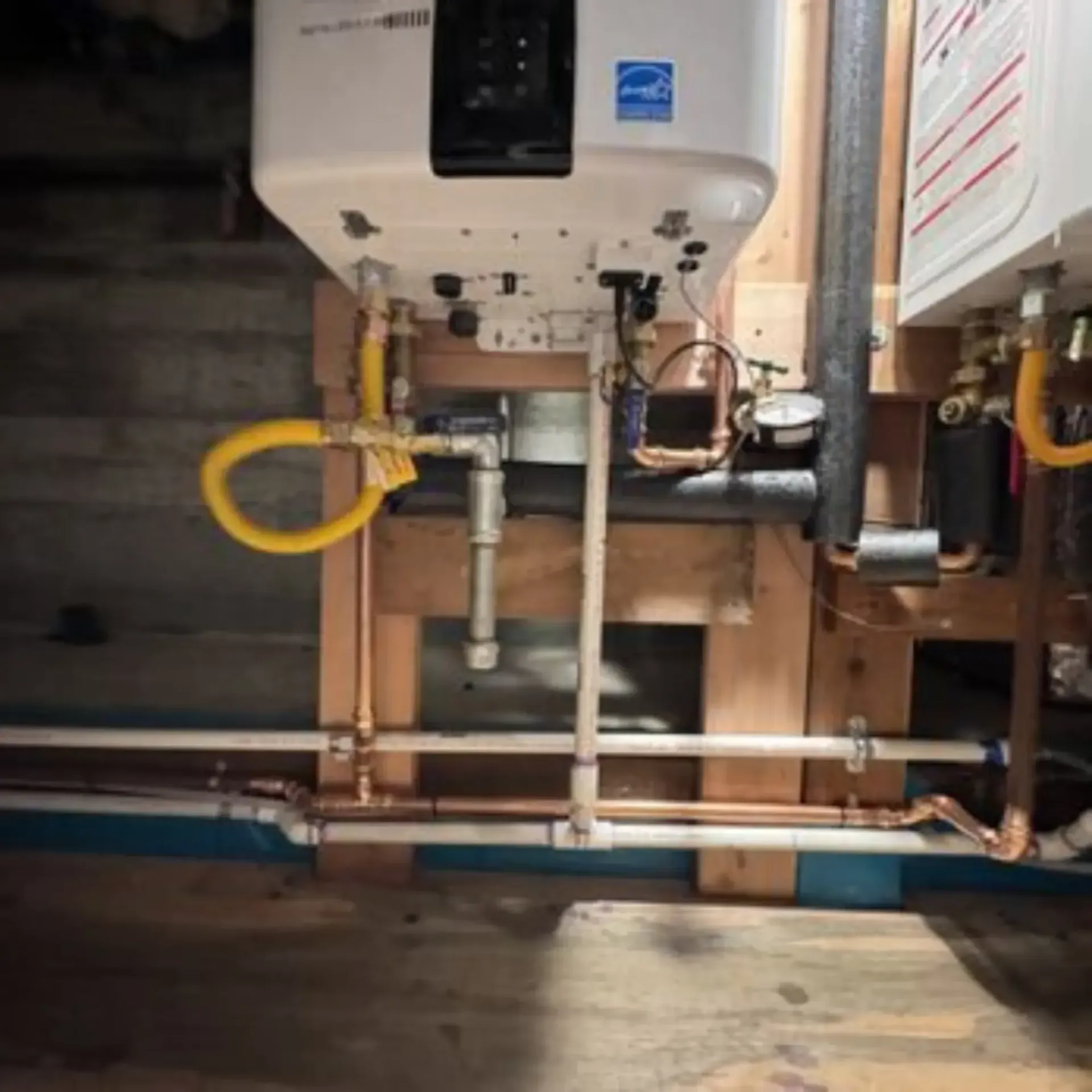 Pipex Plumbing - A water heater is hanging from the ceiling in a basement