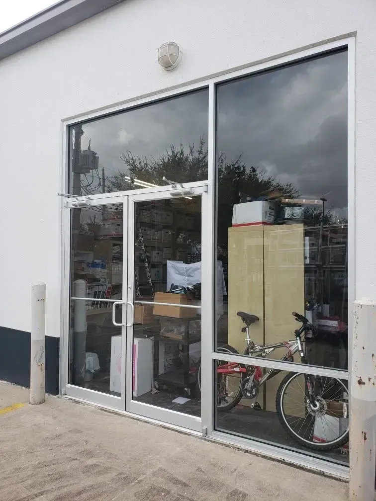 Storefront with large glass windows and a bicycle visible inside the entrance.