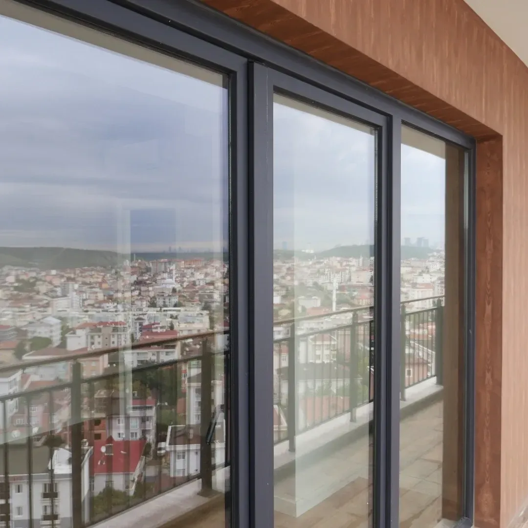 Cityscape seen through a large glass balcony door from an apartment interior