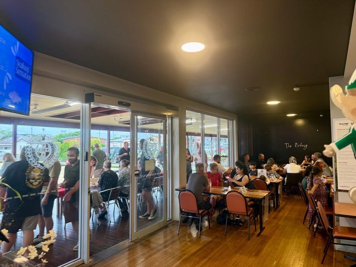 People At Tables and Standing Near an Open Doorway — Taree Railway Bowling Club Ltd in Taree, NSW