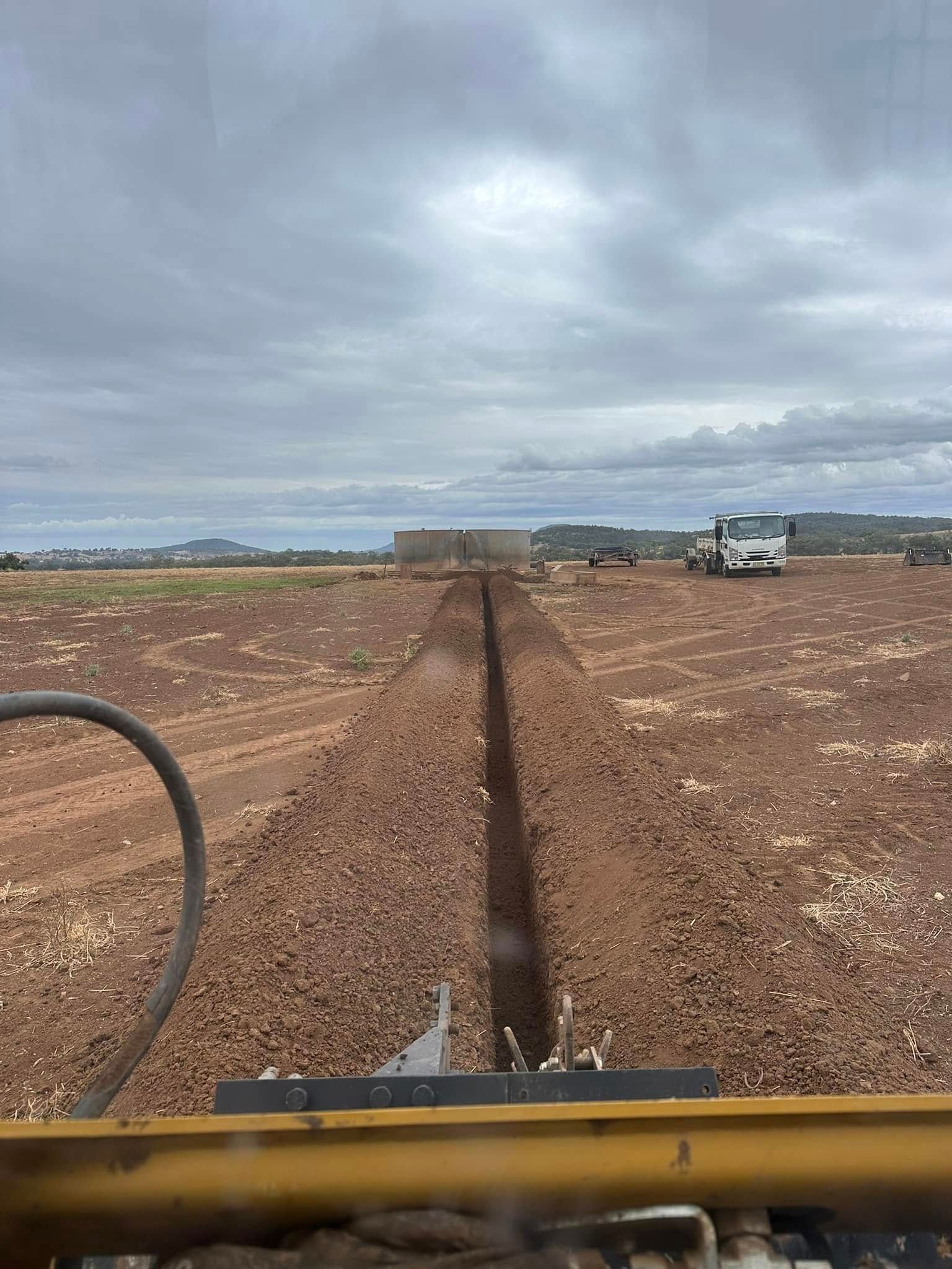 Excavator carrying out drainage earthworks on a regional site