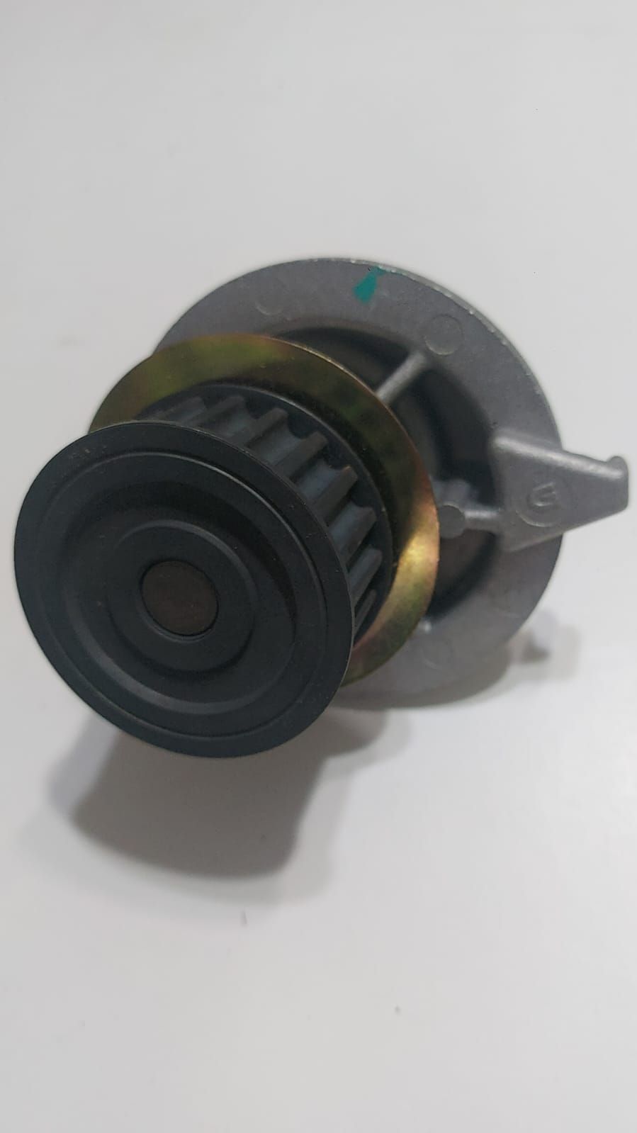 Primer plano de un conector eléctrico negro y gris con base metálica circular y pestillo lateral.