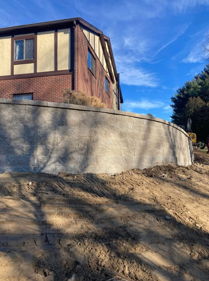 Brick and stucco house with a retaining wall on a sunny day.