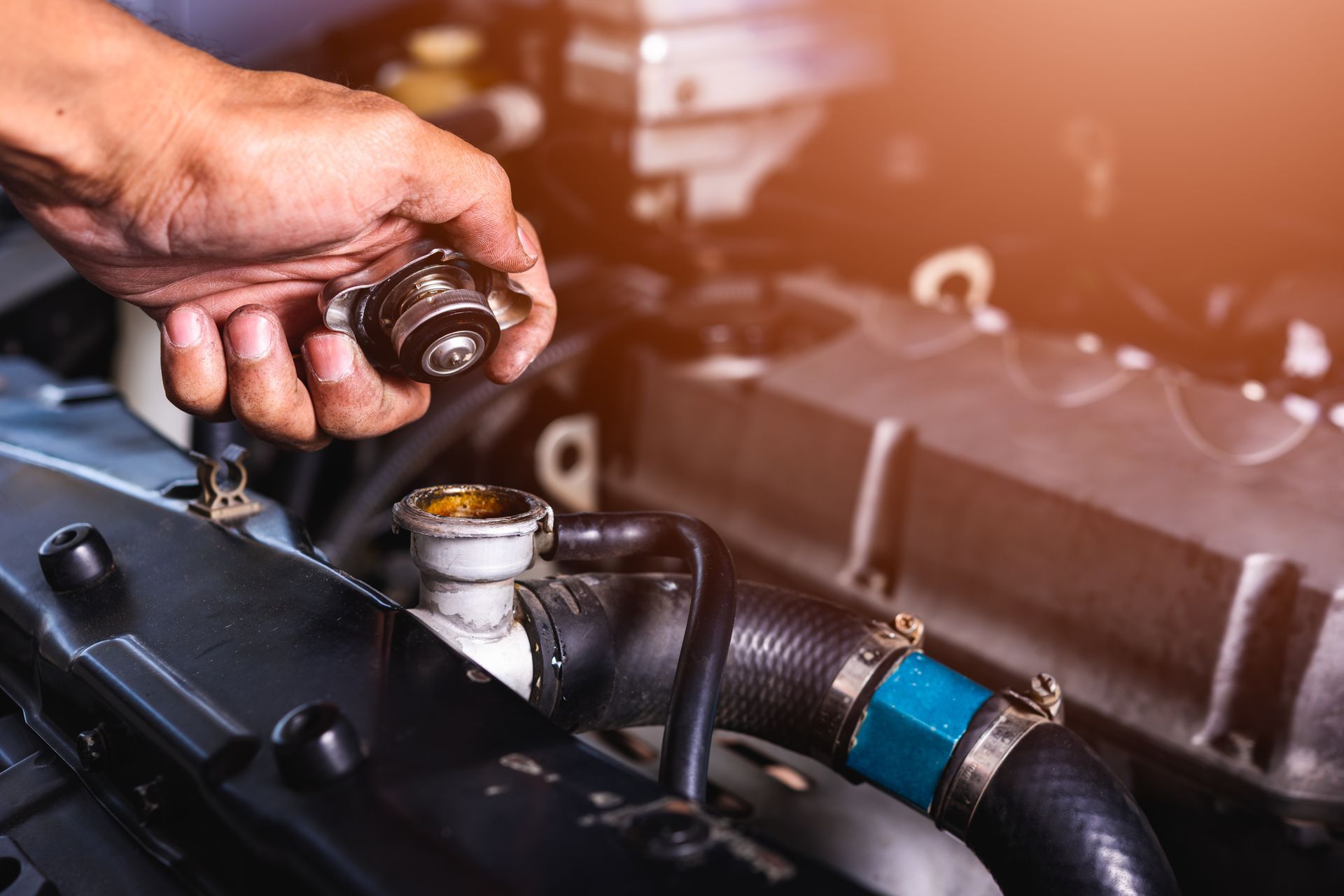 Mechanic checking radiator cap with hand on open coolant reservoir for emergency radiator repair ser