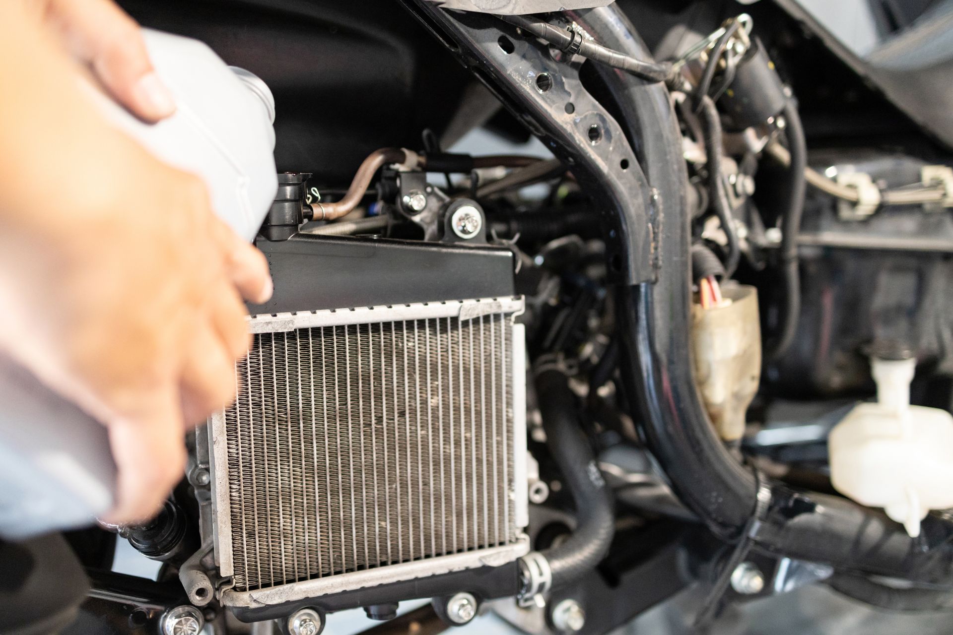 Technician inspecting a radiator tank and cooling system during auto radiator repair service