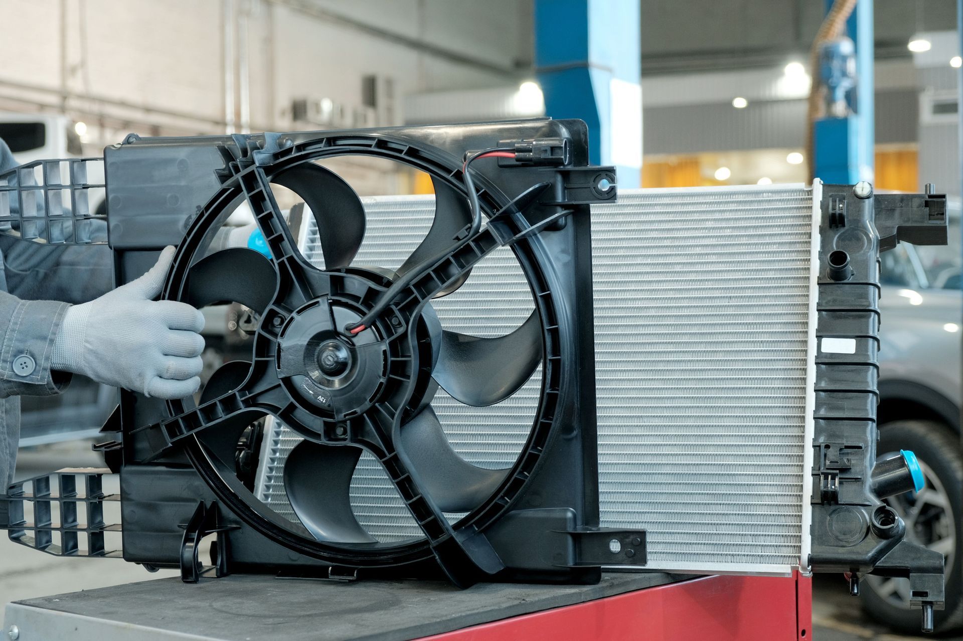 The mechanic ensures the radiator matches with the fan system for smooth cooling.