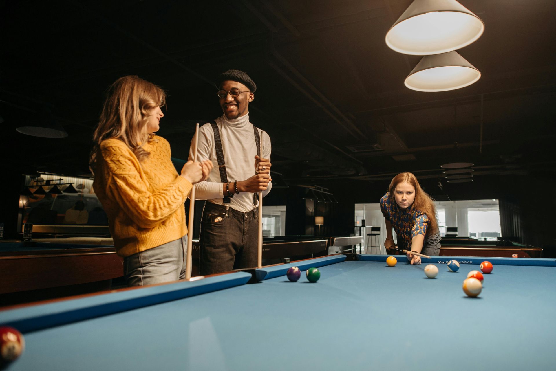 three people playing pool