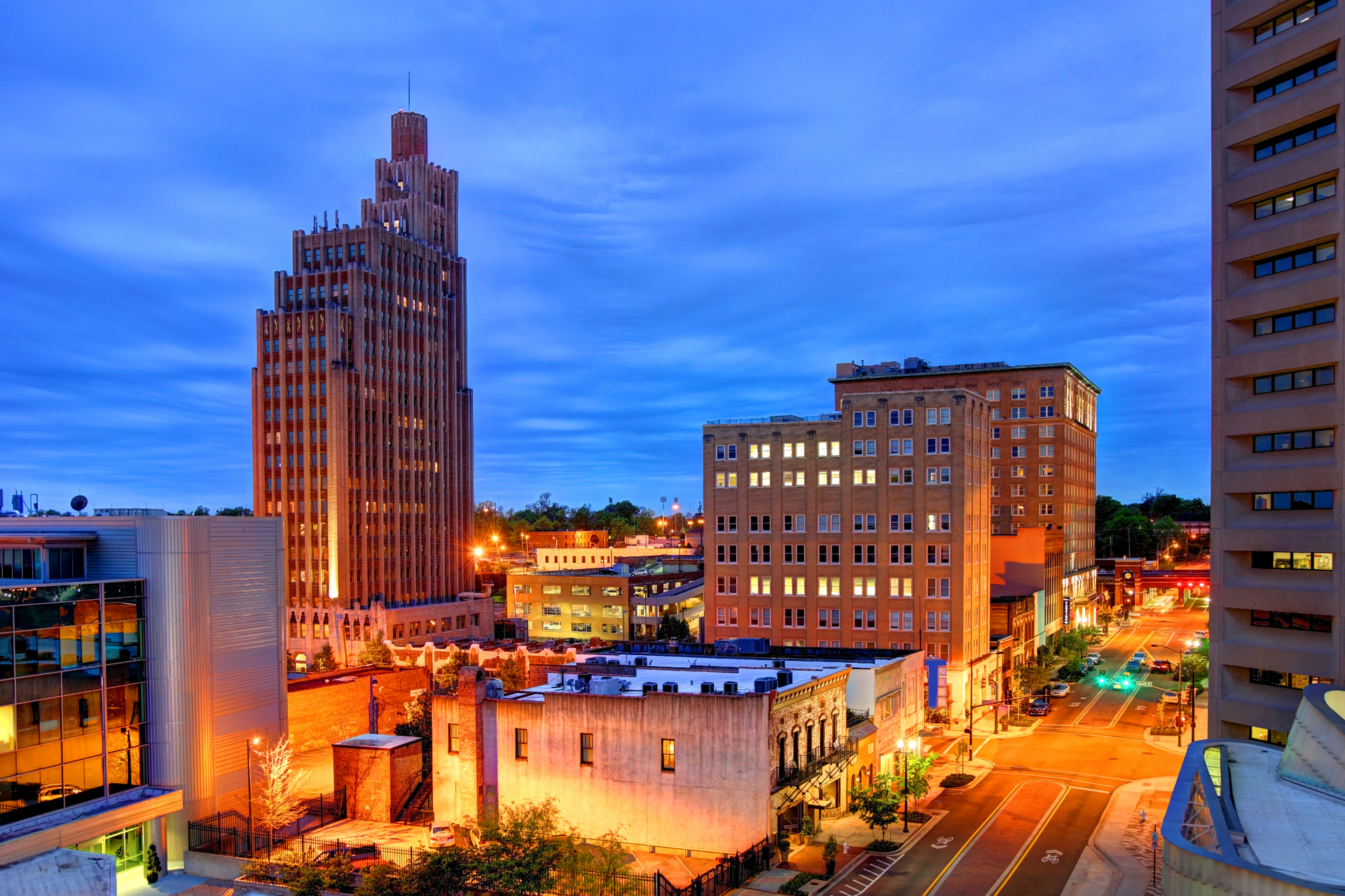 An aerial view of a city at night with a tall building in the background.