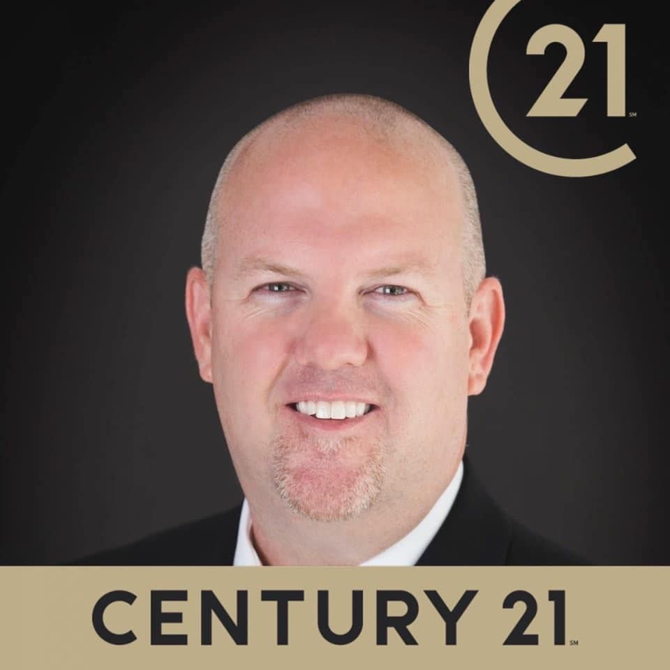 Century 21 logo with a bald man’s headshot on a black background