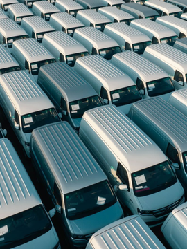 Rows of silver semi-truck trailers parked tightly in a large lot, viewed from above.