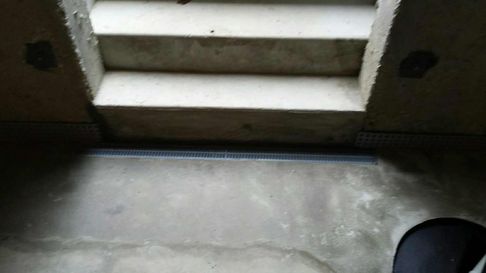 A person is standing in front of a set of stairs.