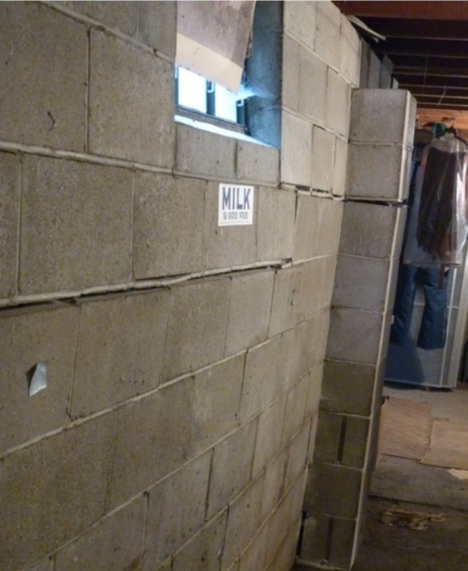 A brick wall with a sign that says milk on it