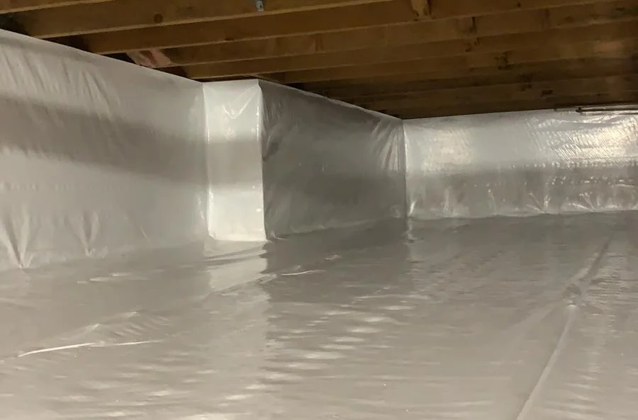 A basement with a lot of plastic on the floor and walls.