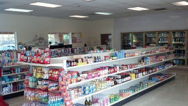 A grocery store filled with lots of shelves of food and drinks.