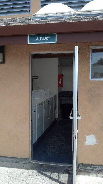 A laundry room with a sign above the door that says laundry
