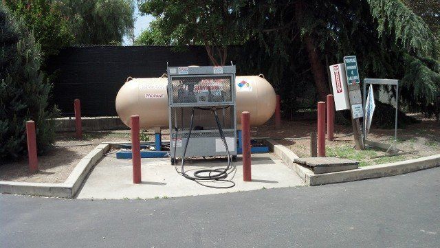 A propane tank is sitting on the side of the road