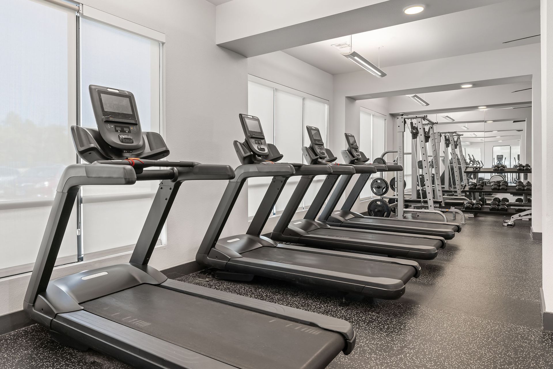 A row of treadmills are lined up in a gym at The Heights offers student apartments for rent near SHSU in Huntsville, TX.