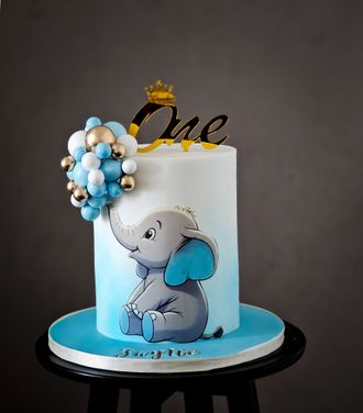 A blue and white cake with an elephant decoration, 