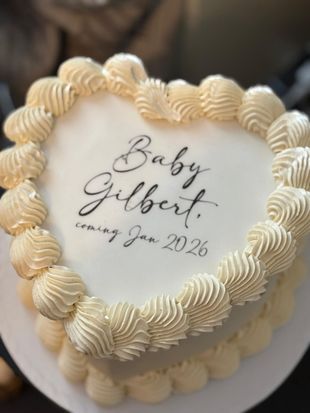 Heart-shaped cake with cream frosting and text that reads 