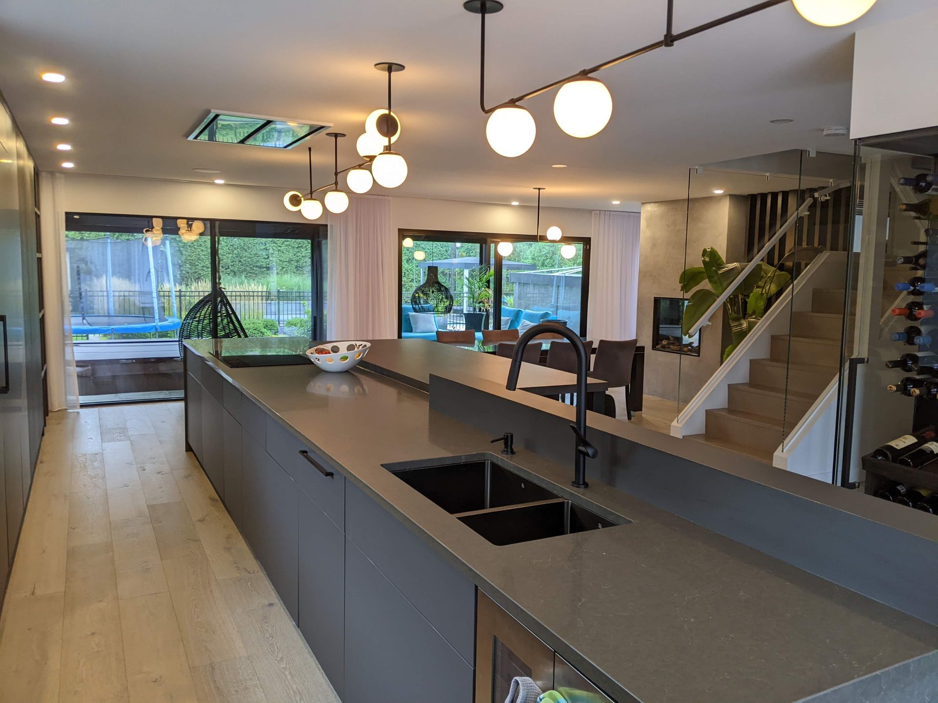 Une cuisine avec un évier et un escalier en arrière-plan.
