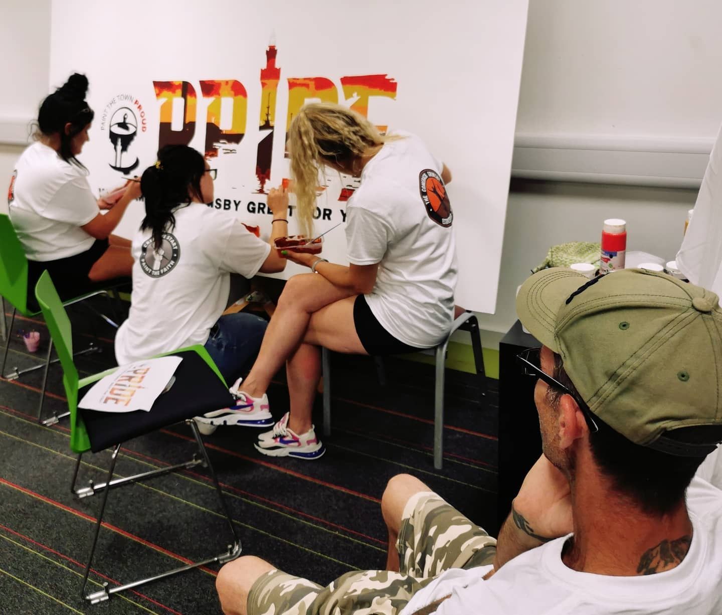 A group of people are sitting in front of a sign that says spice