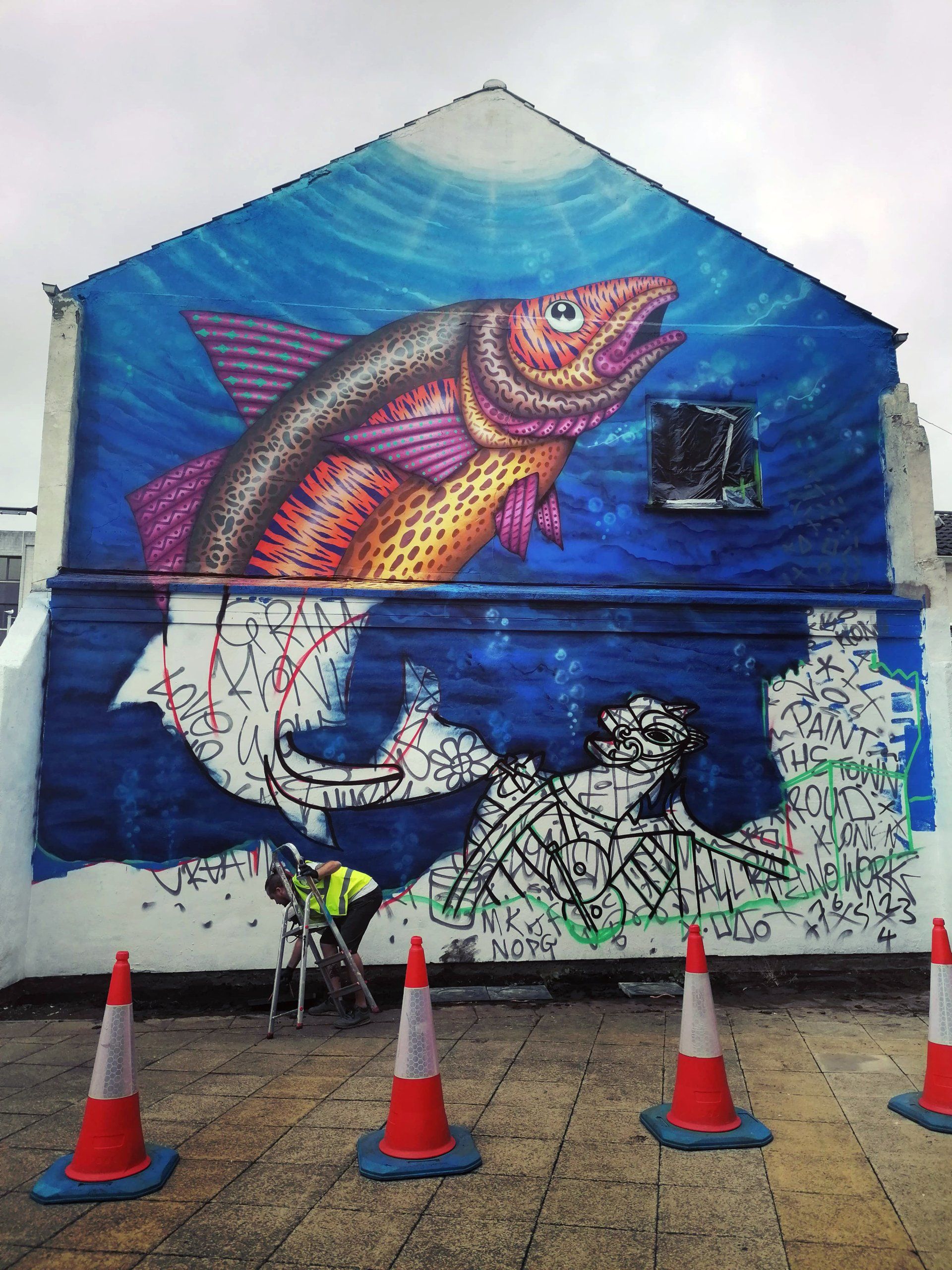 A painting of a fish on the side of a building
