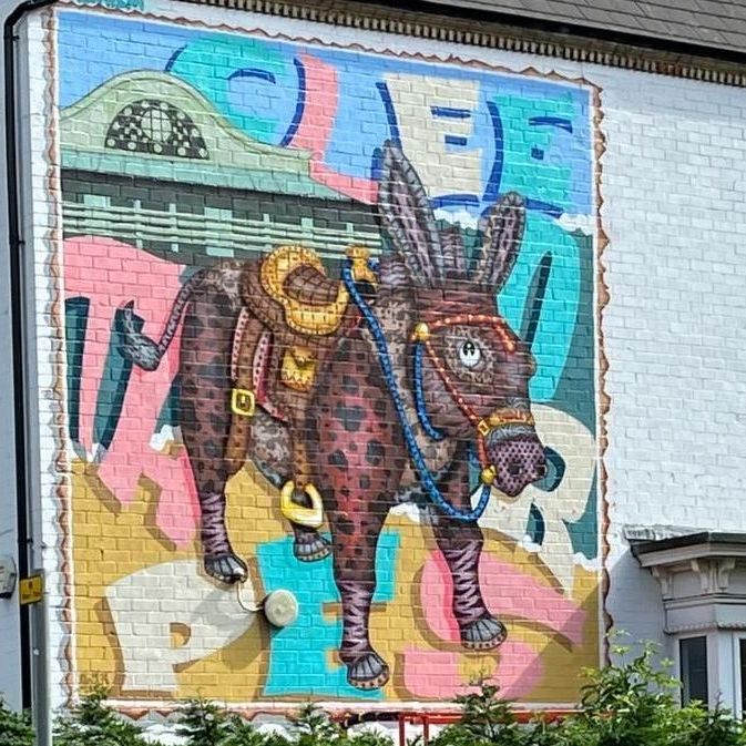 A mural of a donkey with a saddle on its back