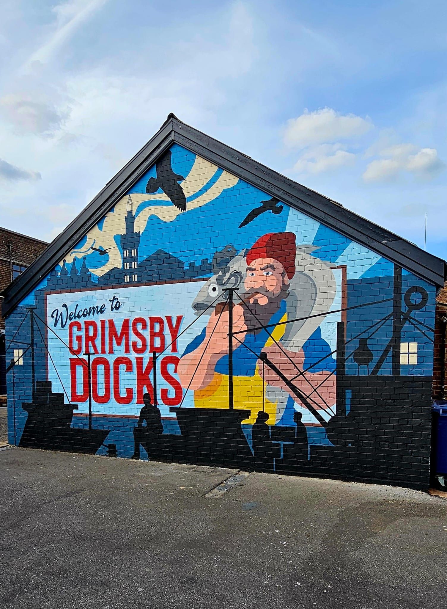 A mural on the side of a building that says grimsby docks