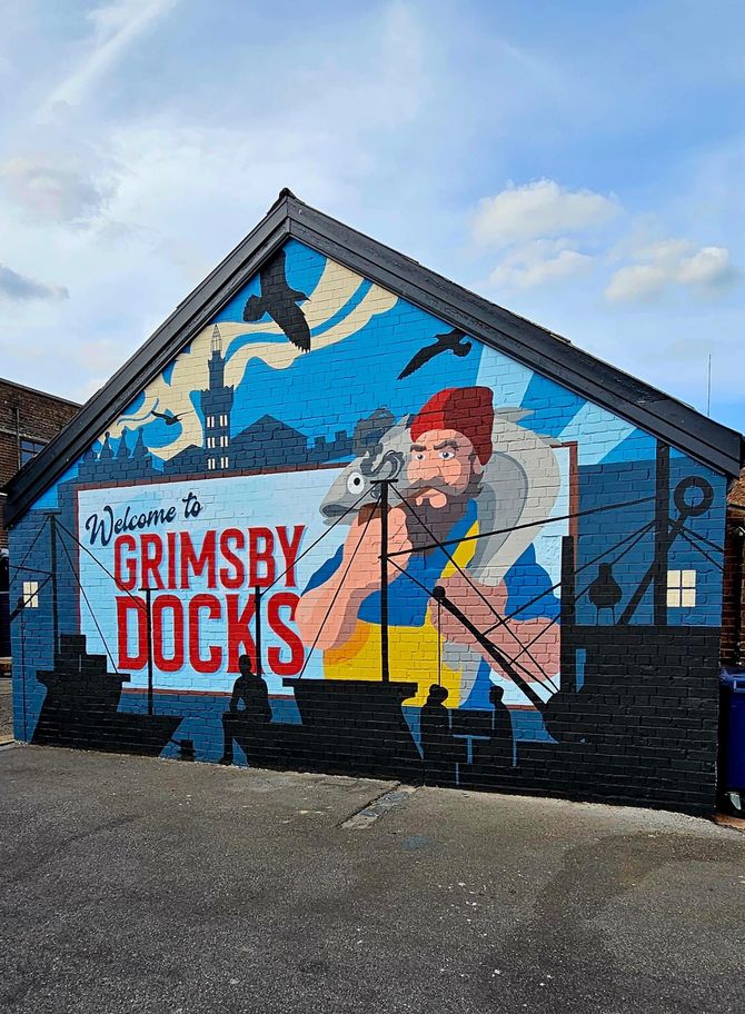 A mural on the side of a building that says grimsby docks