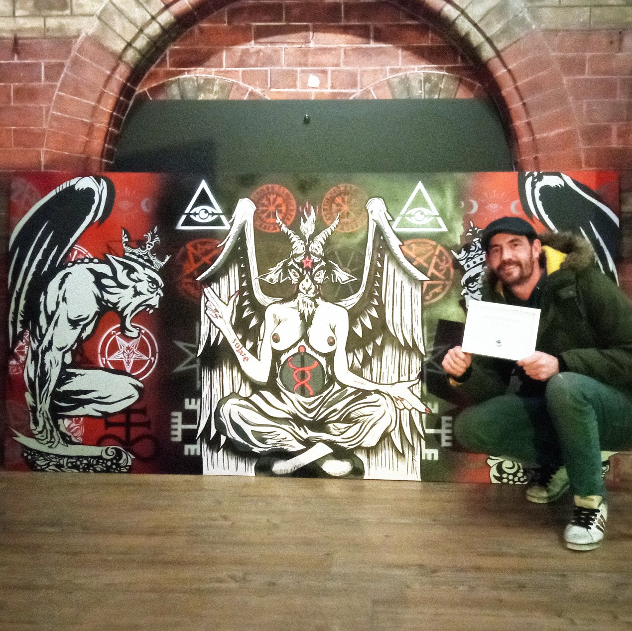 A man is kneeling in front of a large painting