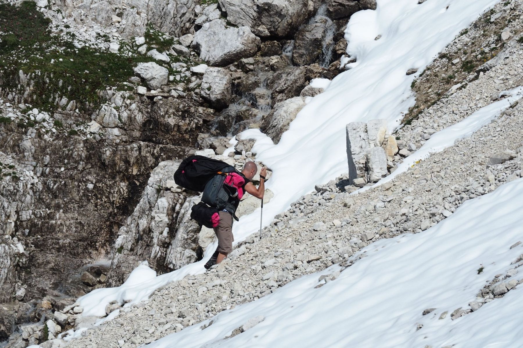 A person with a backpack is climbing a snowy mountain