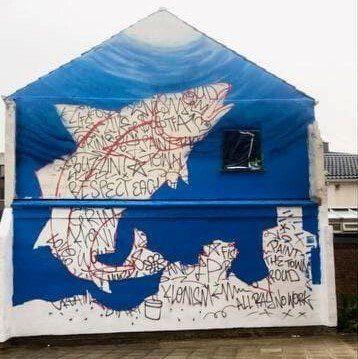 A blue and white building with graffiti on it