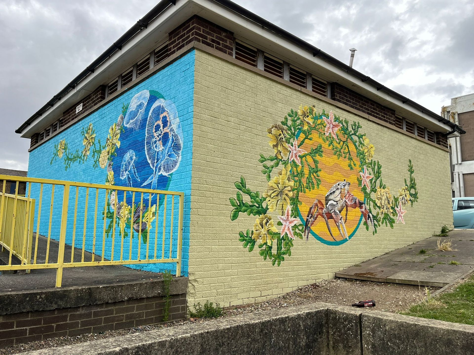 A brick building with a mural on the side of it.