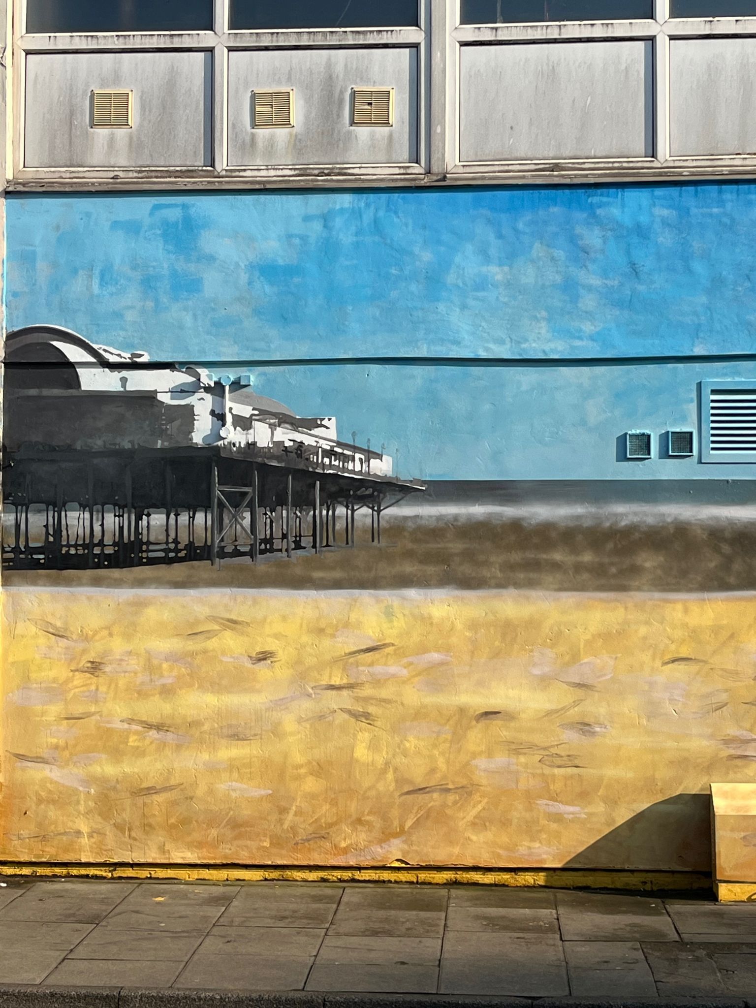 A painting of a pier on the side of a building