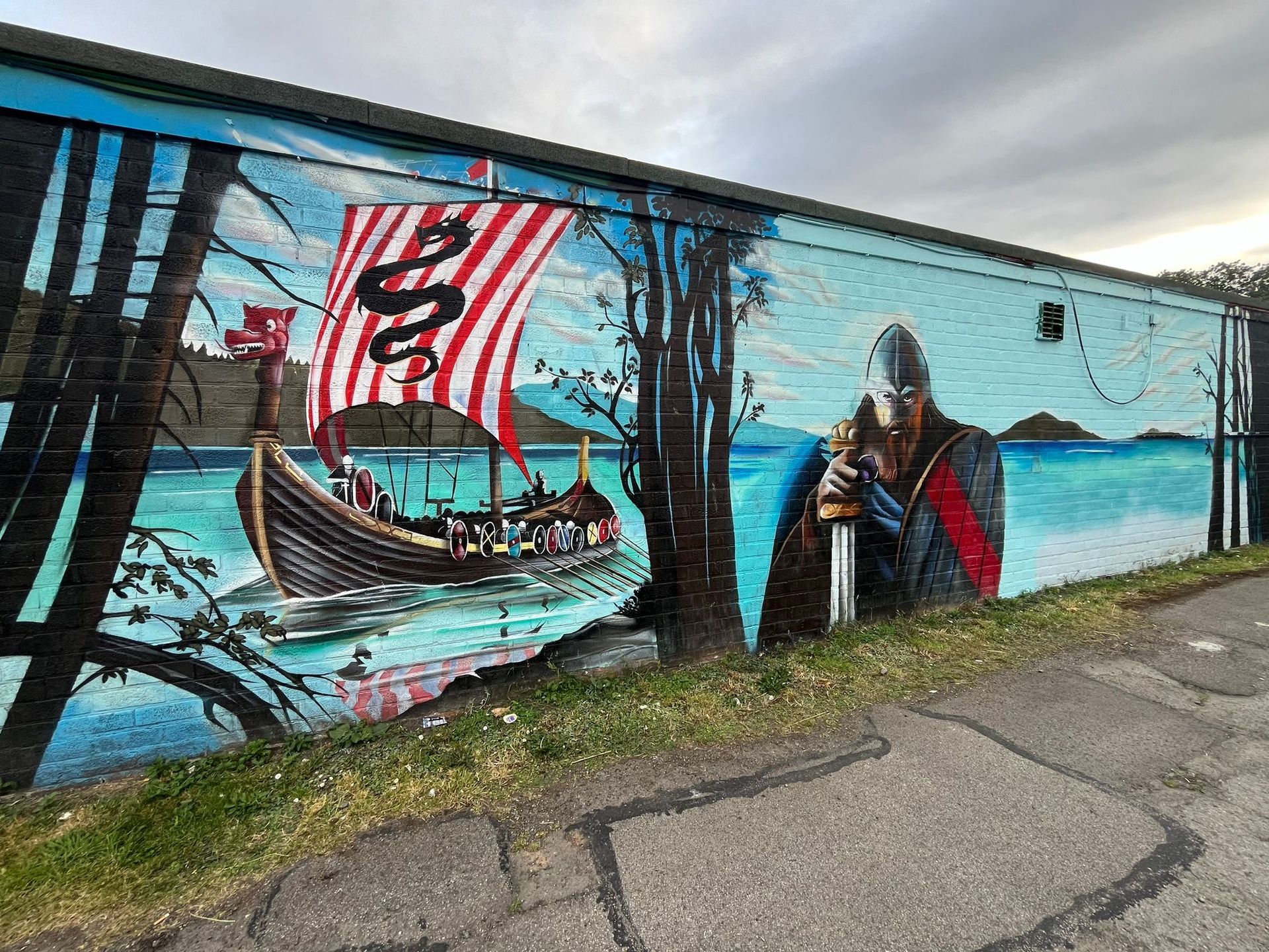 A mural of a viking warrior and a boat on a wall.
