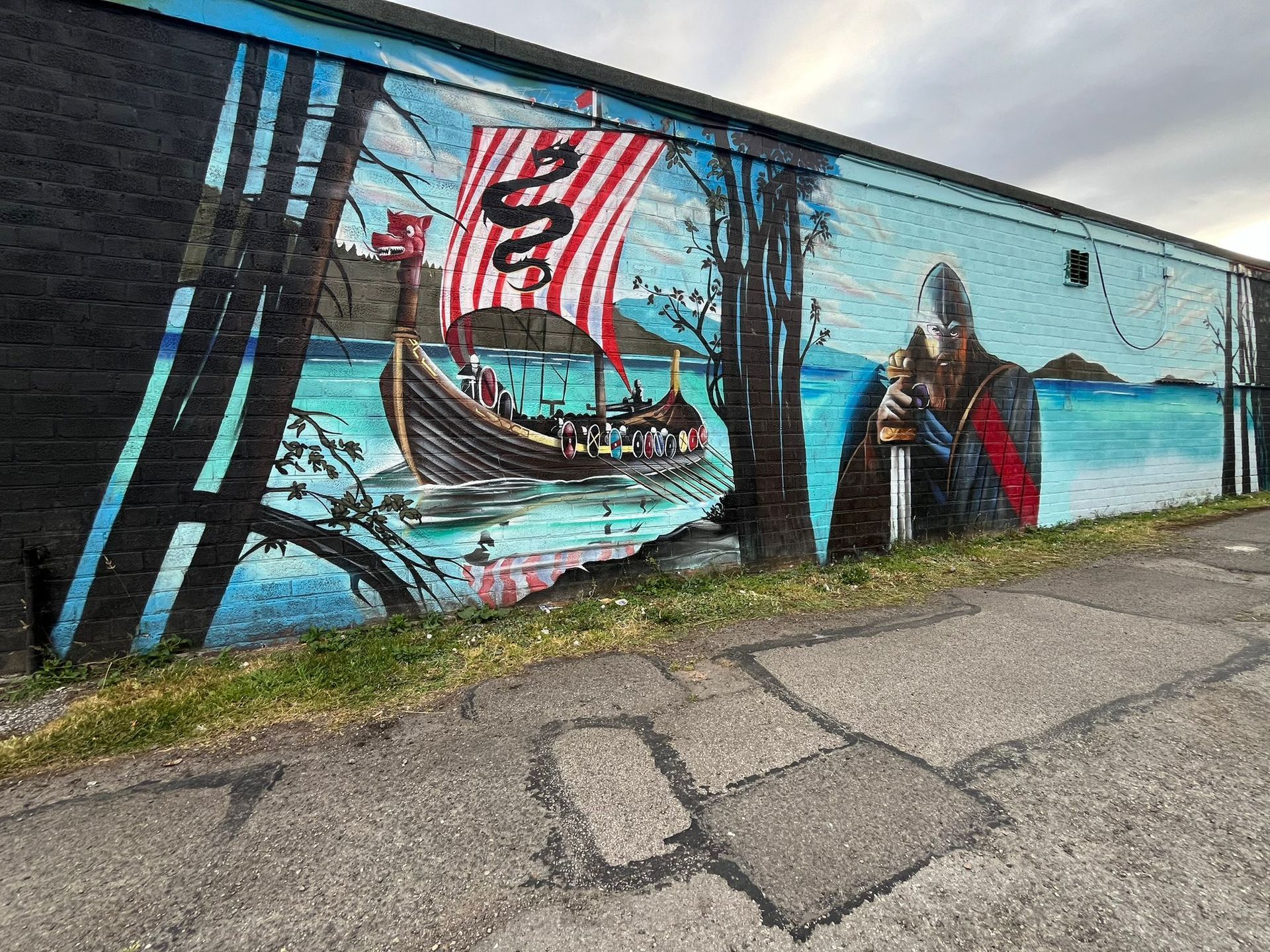A large mural on the side of a building depicting a viking ship.