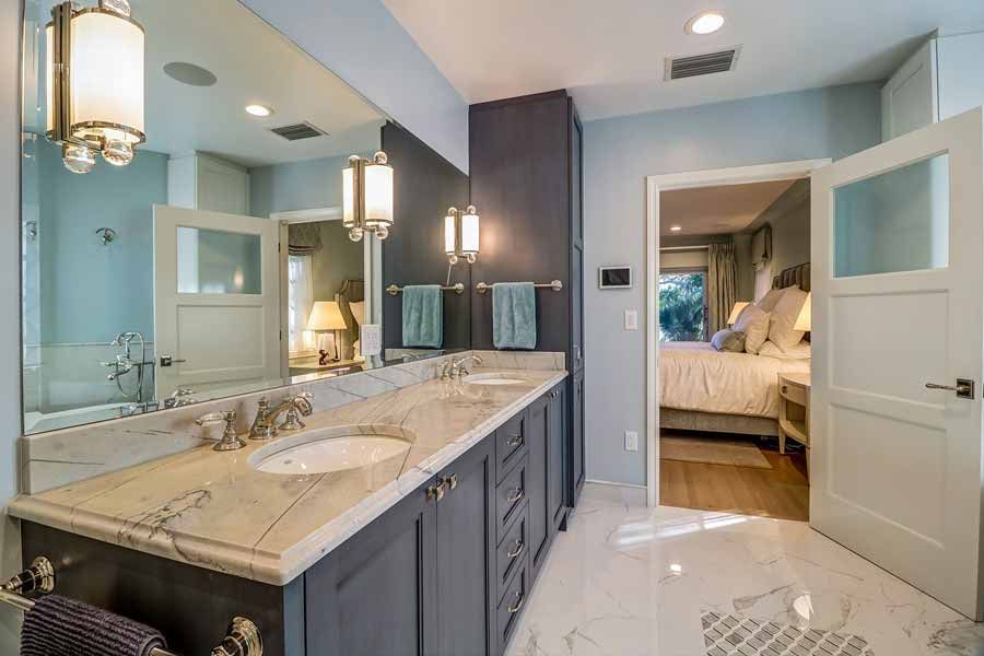 A bathroom with two sinks and a large mirror.